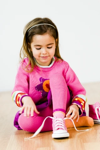 Παιδί που δένει κορδόνια