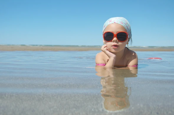 Πανέμορφο κοριτσάκι στην παραλία με γυαλιά ηλίου